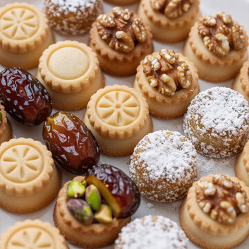Comic Book Eid Up. Detailed Close-Up Of Traditional Arabic Eid Sweets, Showcasing Maamoul Or Mamoul Cookies Filled With Pistachios, Dates, And Walnuts