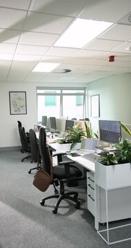 Vertical video: At start camera is panning from left across empty desks to reveal workspace layout