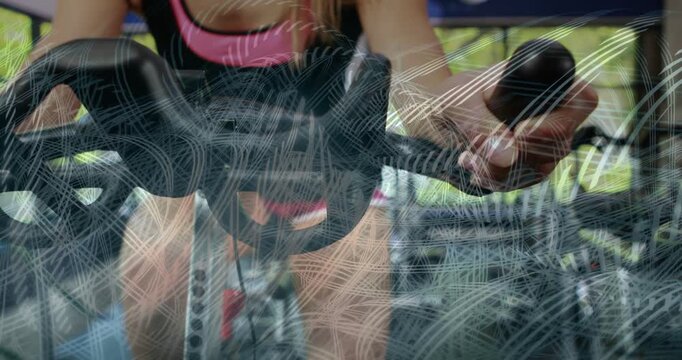 Woman using bike in gym, twisting handle control for harder workout, swirl overlay obscuring