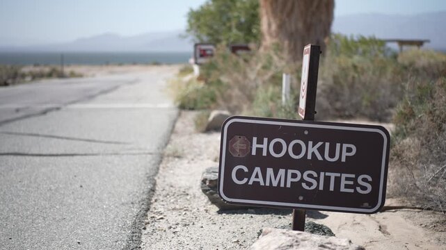 Signs showing hookup campsites for visitors at the Salton Sea Recreation Area in California along the road leading to the campground