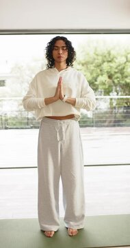 Vertical video: Non-binary person stepping onto yoga mat on balcony practicing mindfulness for calm