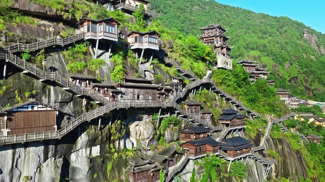 Traditional wooden buildings perched on cliffs in Wangxian Valley Scenic Area, Jiangxi, China.