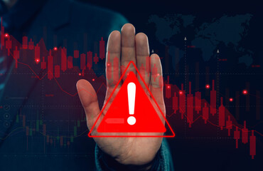 Businessman showing stop hand gesture with warning alert symbol over falling stock market chart representing financial risk market crash, economic crisis investment loss and global trading volatility. © wanchai peatoo