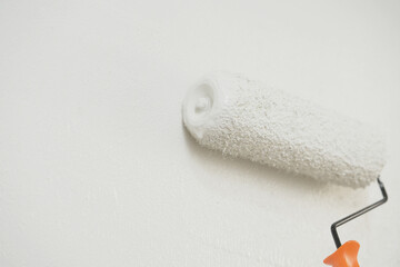 Obraz premium Roller Brush Painting, Worker painting on surface wall Painting apartment, renovating with white color paint. Leave empty copy space to write descriptive text beside. 