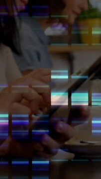 Vertical video: Hands tapping phones and tablet at cafe, sharing on mobile tech with glitch overlay