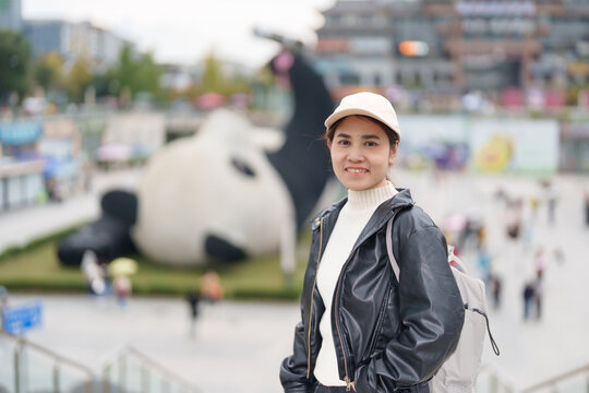 Happy woman traveler travel in Dujiangyan city. Tourist sightseeing Yangtianwo Square and Guanxian Ancient City near Chengdu. Landmark and popular for tourism attraction in Sichuan, China