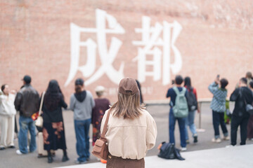 Happy woman traveler travel in Chengdu city. Tourist sightseeing and shopping in Eastern Suburb Memory or Dongjiao Ji Yi. Famous Landmark for tourism attraction in Sichuan, China