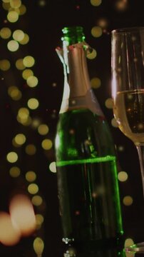 Green champagne bottle sitting on bar, torn foil causing confetti and bokeh flickering for events