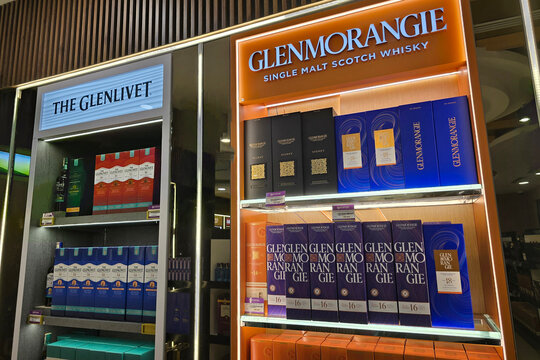 Penang, Malaysia- Jan 06, 2026: A retail display inside the Eraman duty-free shop at Penang International Airport featuring various editions of Glenmorangie and The Glenlivet single malt Scotch whisky