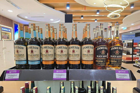 Penang, Malaysia- Jan 06, 2026: Rows of Jameson Triple Triple and Black Barrel Irish Whiskey bottles on retail shelves at an Eraman duty free store in Penang International Airport departure hall.