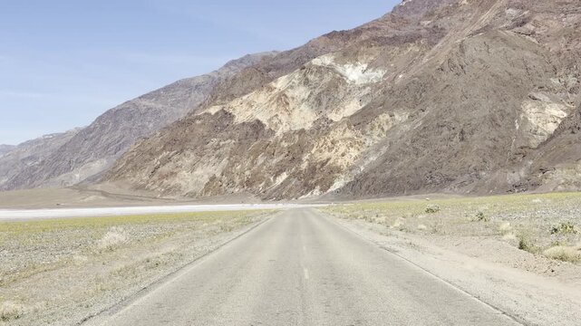 Driving Along Badwater Road Past Colorful Eroded Mountains
