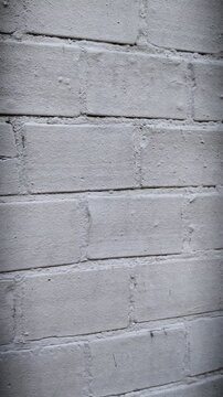 Vertical pan of grey concrete block wall texture. Raw industrial building material surface.