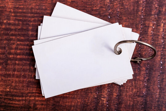 Blank white flashcards with metal ring on a dark wooden background. Minimalist study mockup with copy space for text.