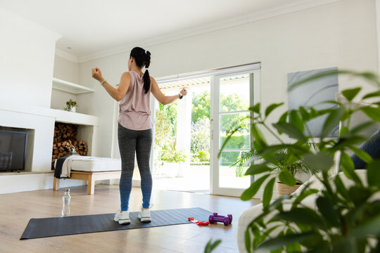 Woman starting workout on mat gripping handles and showing animated fitness stats tracking progress