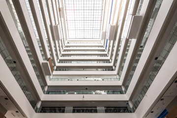 Fototapeta premium Modern architectural atrium with glass skylight viewed from below showing structural geometry