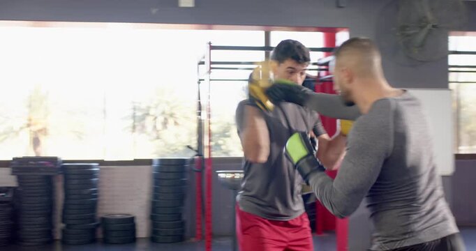 Diverse male partners following mitt cues and trading jab&ndash;cross, hook and uppercut combos in gym