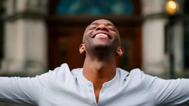 Man with arms outstretched in celebration and joy with eyes closed and head tilted back