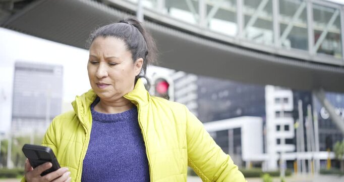Reading text on smartphone, woman scanning corner traffic light and smiling after friend arrival
