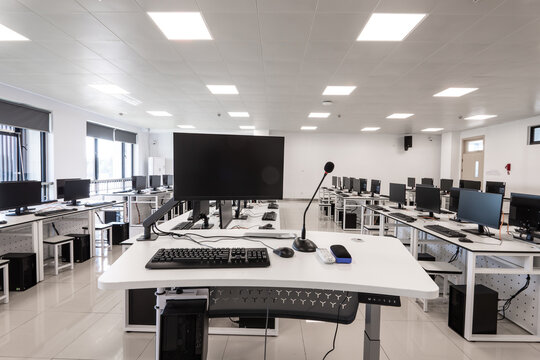 Modern computer classroom with neatly arranged equipment and workstations
