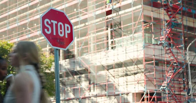Diverse female pedestrians entering, passing red STOP sign on sidewalk while commuting, copy space