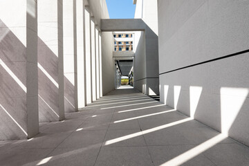 Naklejka premium Modern architectural corridor with intersecting light and shadow patterns