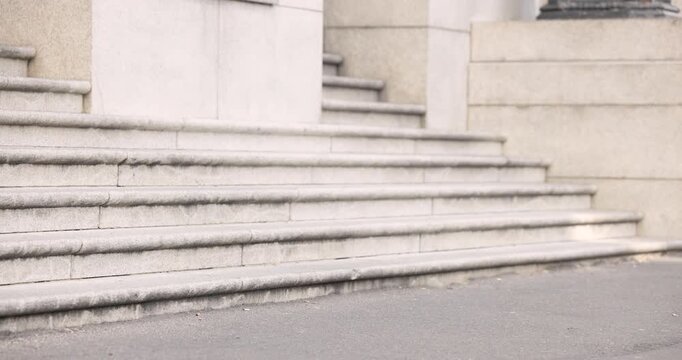 Diverse passersby commuting past steps as hand passing camera showing runner sprinting with bags