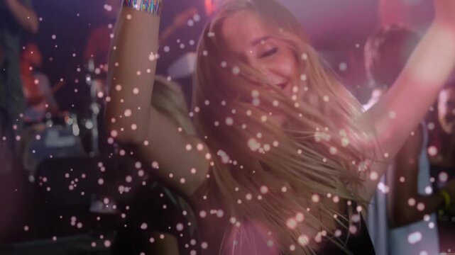 Woman raising beer mug and dancing, music driving animated confetti overlaying her and band
