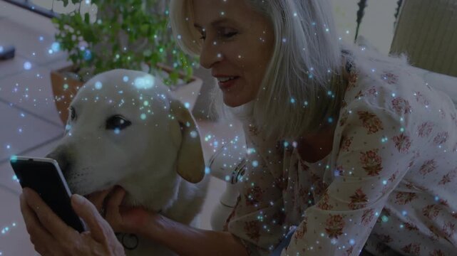 Senior woman holding smartphone, bringing screen closer to dog, sharing tech, sparkles overlaying