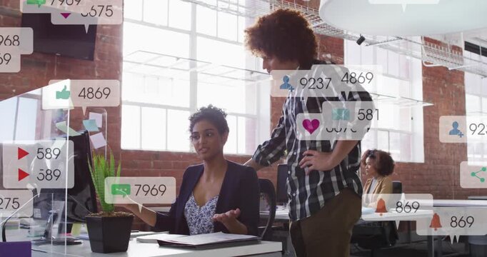 Woman pointing, man standing watching, social icons popping then fading on screen, reviewing ads
