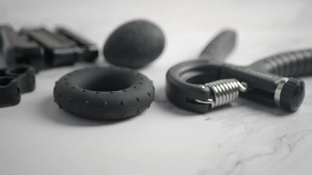 A collection of hand and finger strengthener tools featuring a grip exerciser, an egg-shaped stress ball, a circular hand exerciser, and a finger resistance band