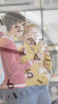 Vertical video: Seeing clock overlay two staff wearing sweaters sipping cups in office on break IDs