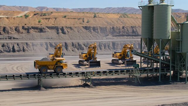 Heavy machinery operating at a large open pit mine site with earth movers and excavators