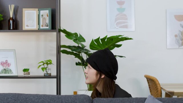Asian Female Thief in Black Beanie Rummaging Through Living Room