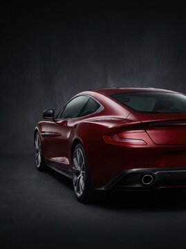 Luxury sports car rear quarter view. Power and refined elegance in deep red.