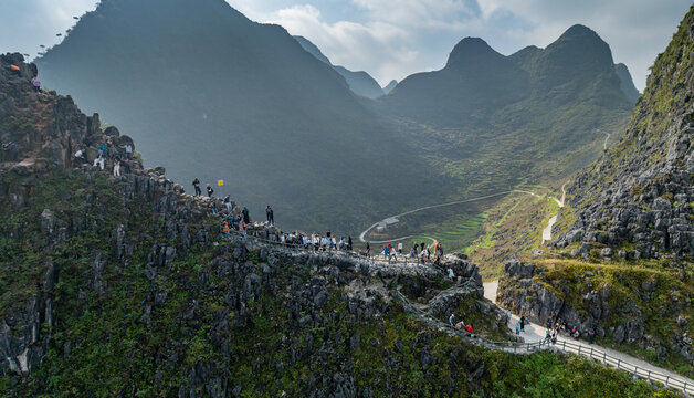 In Ha Giang, Vietnam, tourists hike the mountain pass of Meo Vac, Ha Giang, Vietnam, to take in the view of the valley below. The path is narrow and steep, but the views are worth it.