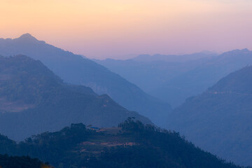 Naklejka premium A scenic view of the mountains in Dong Van, Ha Giang, Vietnam. The image captures the natural beauty of the landscape, with its rolling hills and lush greenery in a blue hue.