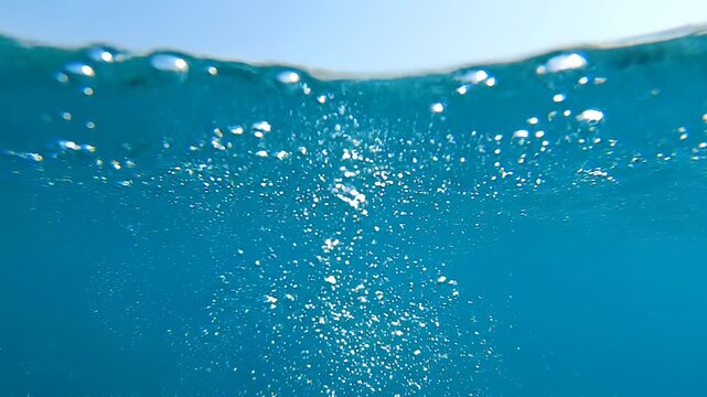 Bubbles rising from the depths of the ocean, a mesmerizing underwater view showcasing the beauty of aquatic life and the clear blue water