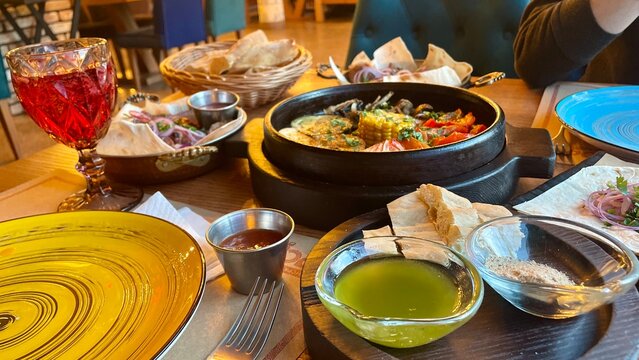Traditional grilled lula kebab served on pita bread with fresh onions and side dishes in restaurant