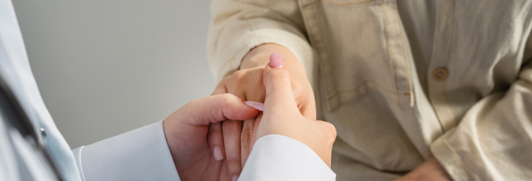 The doctor is empathizing with the patient, holding his hand.