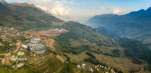 Aerial view of Sapa, Vietnam, showcasing the Hotel de la Coupole - MGallery, nestled in the mountains. The hotel stands out with its unique architecture and design. © Zenstratus