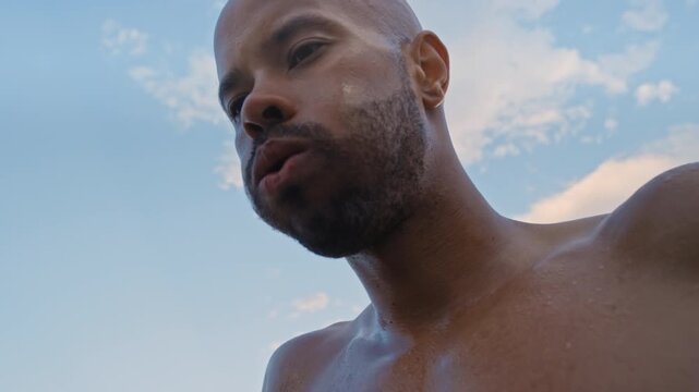 Breathing, tired and black man outdoor for fitness, cardio training and heart rate monitor belt for break. Fatigue, below and sweaty runner with exercise tech for body pulse, workout pause and rest