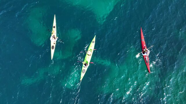 Aerial drone top down cinematic video of athletes practice sport canoe in tropical exotic island emerald crystal clear calm sea