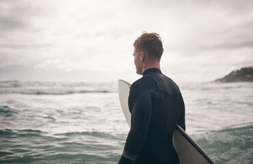Fototapeta premium Fitness, surfboard and man in ocean for practice, water sport and summer training for weekend workout. Back, outdoor activity and athlete with surfing gear for adventure, sunshine or exercise in Bali