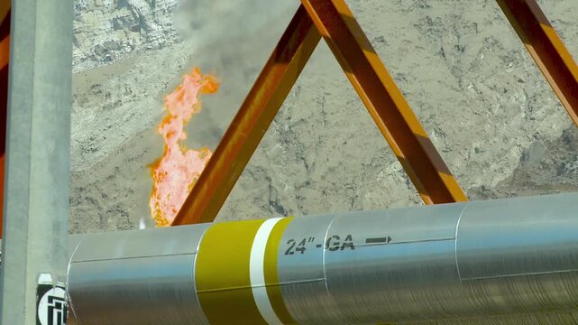Big gas flare behind gas pipeline at Asalouyeh, Iran. Asalouyeh is the onshore location for the phased development of Iranian part of Pars gas field, the largest gas field in the world