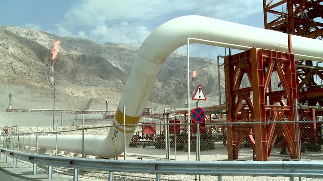 Big gas flares behind gas pipeline at Asalouyeh, Iran. Asalouyeh is the onshore location for the phased development of Iranian part of Pars gas field, the largest gas field in the world