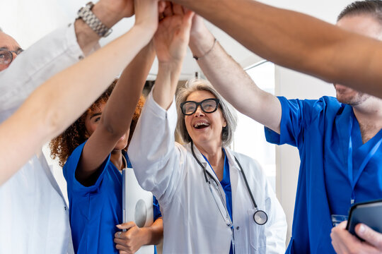 Diverse medical team collaborating with high five gesture