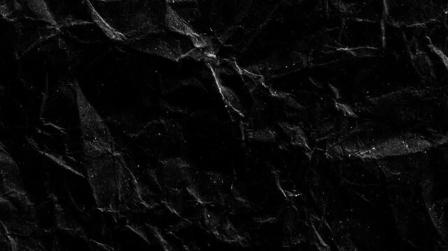 Dark grunge black crumpled paper texture loop background. Premium realistic paper texture for video overlay, titling, and transitions.