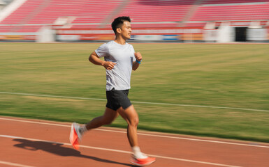 Fototapeta premium An athlete is seen running on the track during his training session showcasing dedication