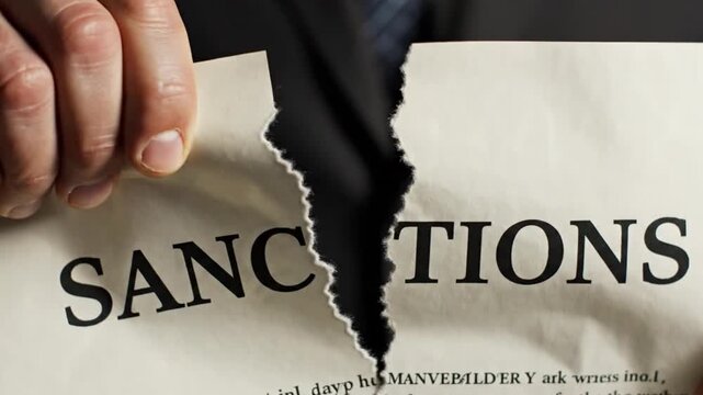 Man tearing paper with sanctions text.