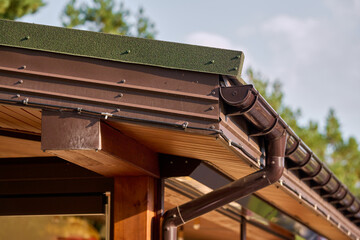 Roof line with brown gutters and wood soffit © Andrey